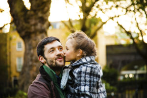Daughter kisses her father on a cheek
